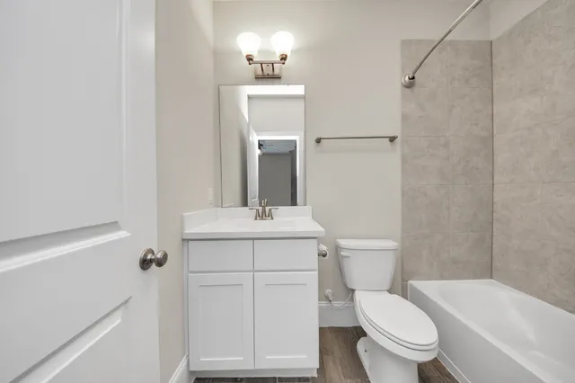 a bathroom with a sink a toilet a mirror and shower