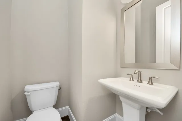 a bathroom with a sink a toilet and a mirror