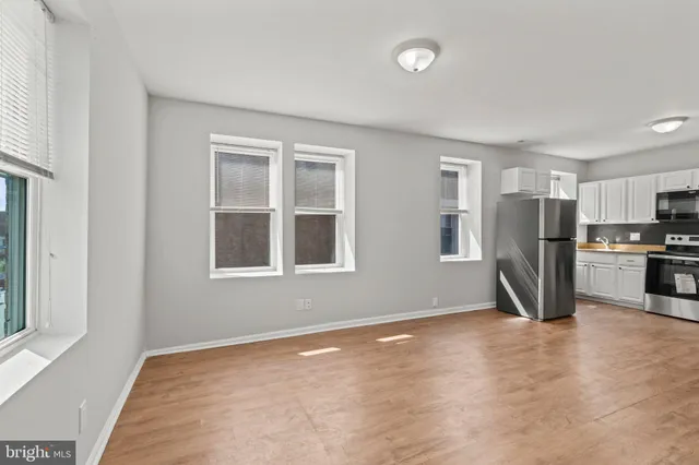 a view of kitchen with stainless steel appliances granite countertop a refrigerator and a stove top oven