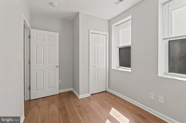 a view of an empty room with closet and a window