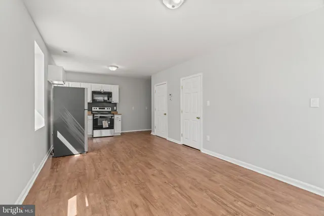 a view of empty room with wooden floor