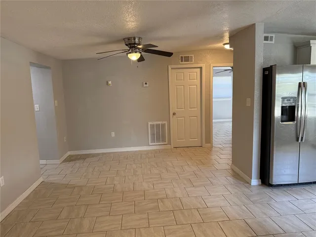 a view of a kitchen with wooden cabinet and a refrigerator