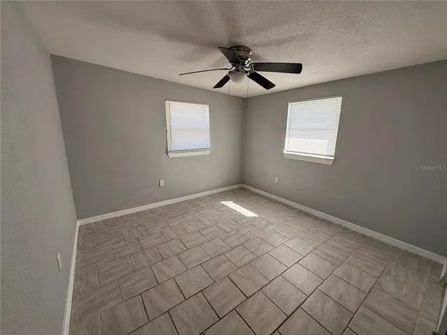 an empty room with closet and fan