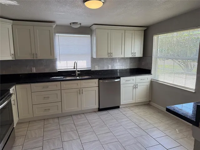 a kitchen with stainless steel appliances granite countertop a refrigerator a stove and cabinets