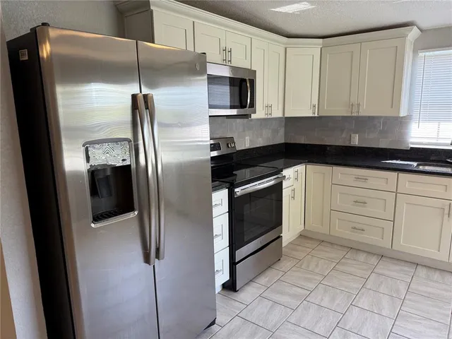 a kitchen with cabinets stainless steel appliances and a counter space