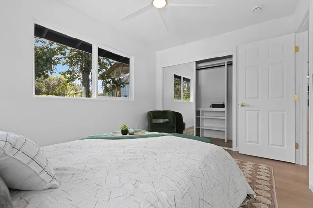 a bedroom with a bed and a painting on the wall