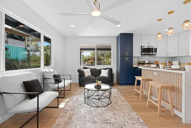 a living room with furniture a large window and a dining table