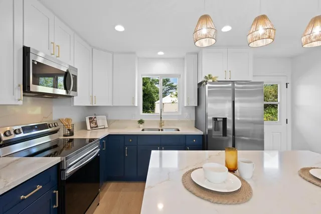 a kitchen with stainless steel appliances a sink a microwave a refrigerator and a stove