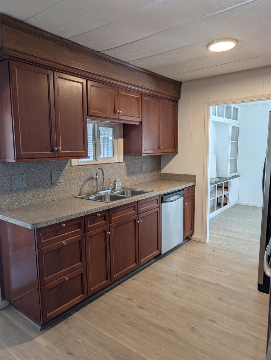 9484 99 Frontage Road, Unit 36 Stockton, CA 95212 - Photo 7 of 8 a kitchen with stainless steel appliances granite countertop wooden cabinets a sink and dishwasher