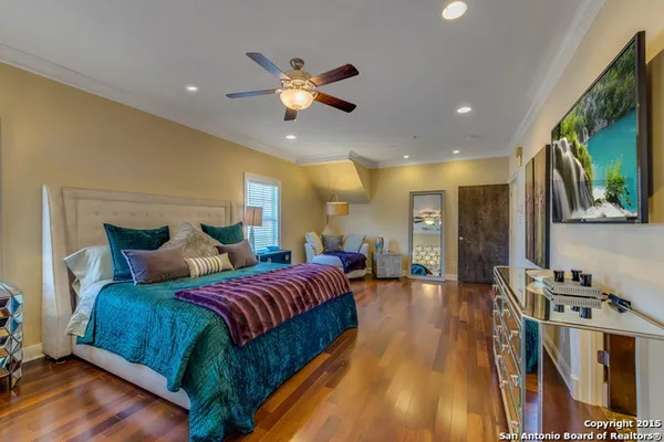 a spacious bedroom with a bed and a chandelier