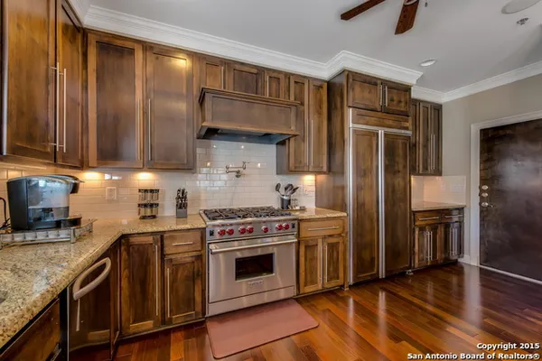 a kitchen with stainless steel appliances granite countertop a stove a refrigerator and a sink