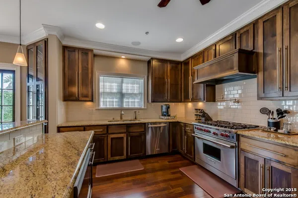 a kitchen with stainless steel appliances granite countertop a sink stove and cabinets