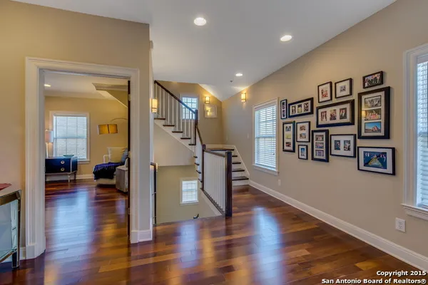 a view of a hallway with wooden floor and furniture