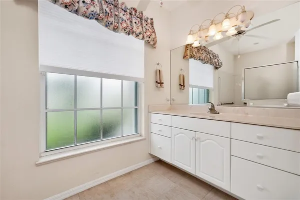 an empty room with a ceiling fan and a window