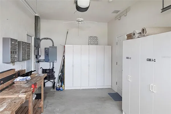 a white house with a big yard plants and large trees