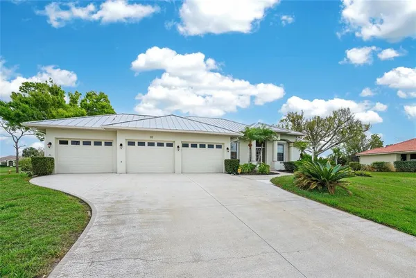 an aerial view of a residential houses with outdoor space and trees
