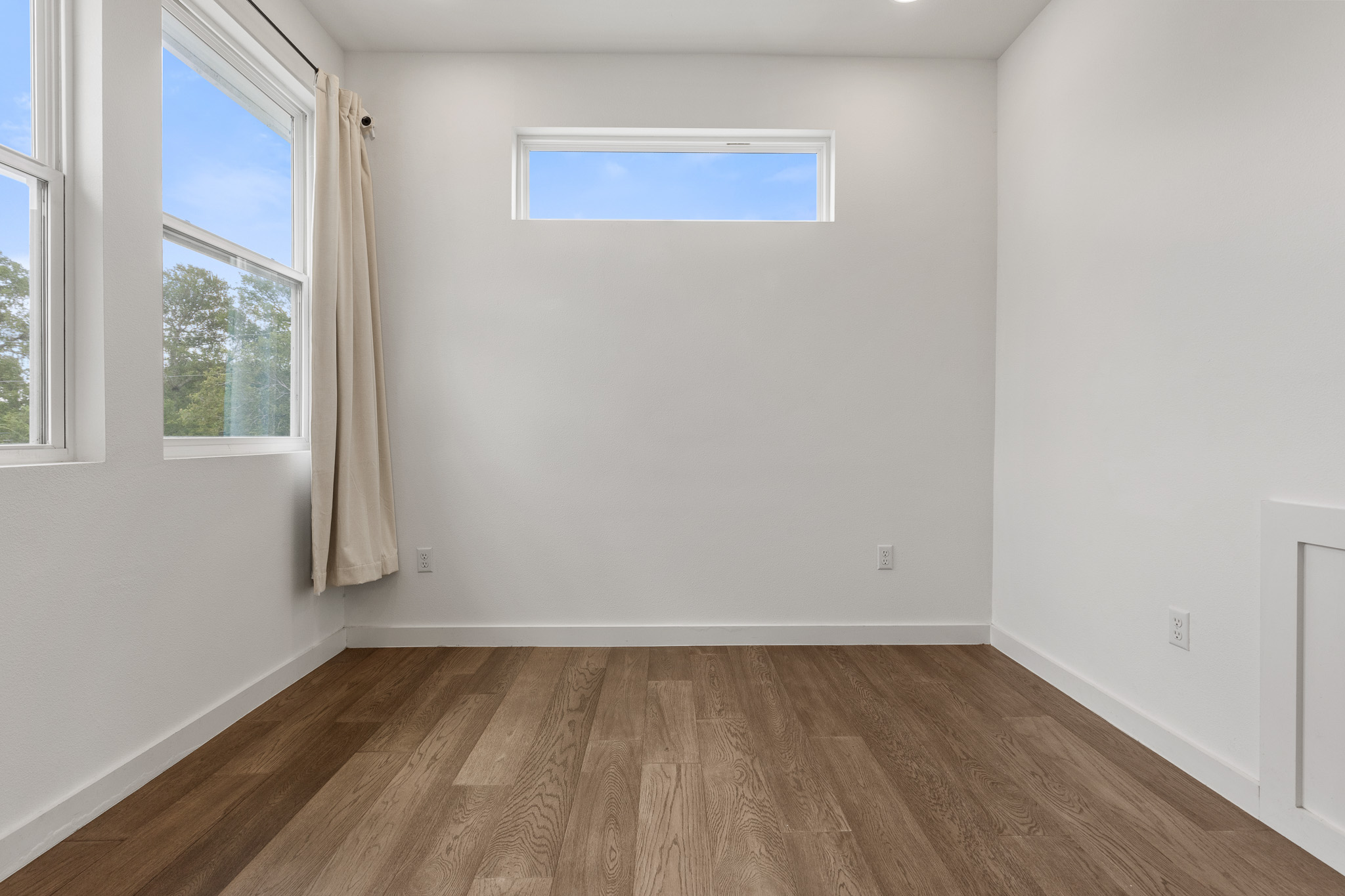 2604 Wheless Lane, Unit 1 Austin, TX 78723 - Photo 25 of 38 Warm hardwood flooring complements neutral white walls for a serene environment.