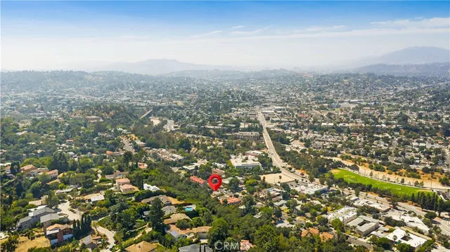 an aerial view of house with yard and mountain view in back