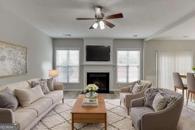 a living room with furniture a fireplace and a flat screen tv