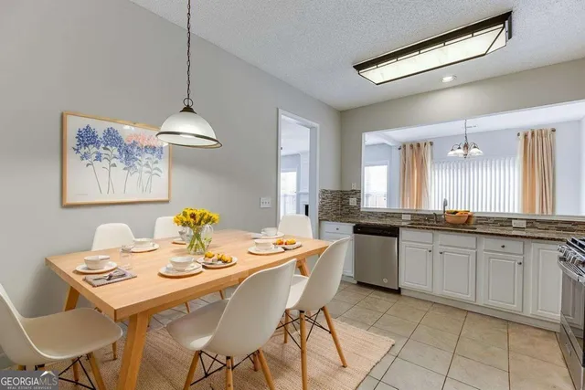 a kitchen with a table chairs and white cabinets