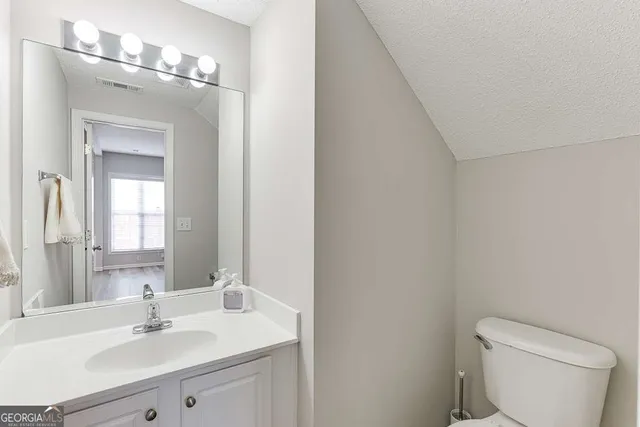 a bathroom with a sink vanity mirror and toilet