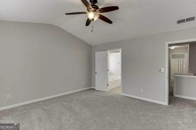 an empty room with closet and a chandelier fan