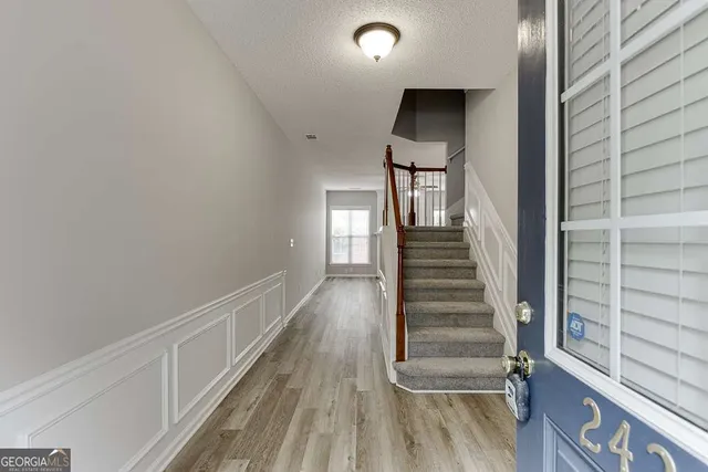 a view of a hallway with wooden floor and entryway