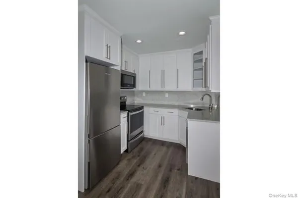 a kitchen with a refrigerator sink and cabinets