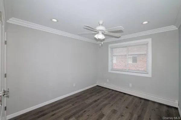 an empty room with wooden floor and window