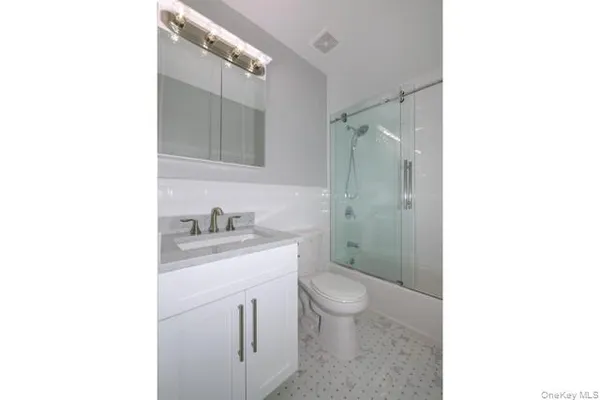 a bathroom with a granite countertop sink toilet and shower