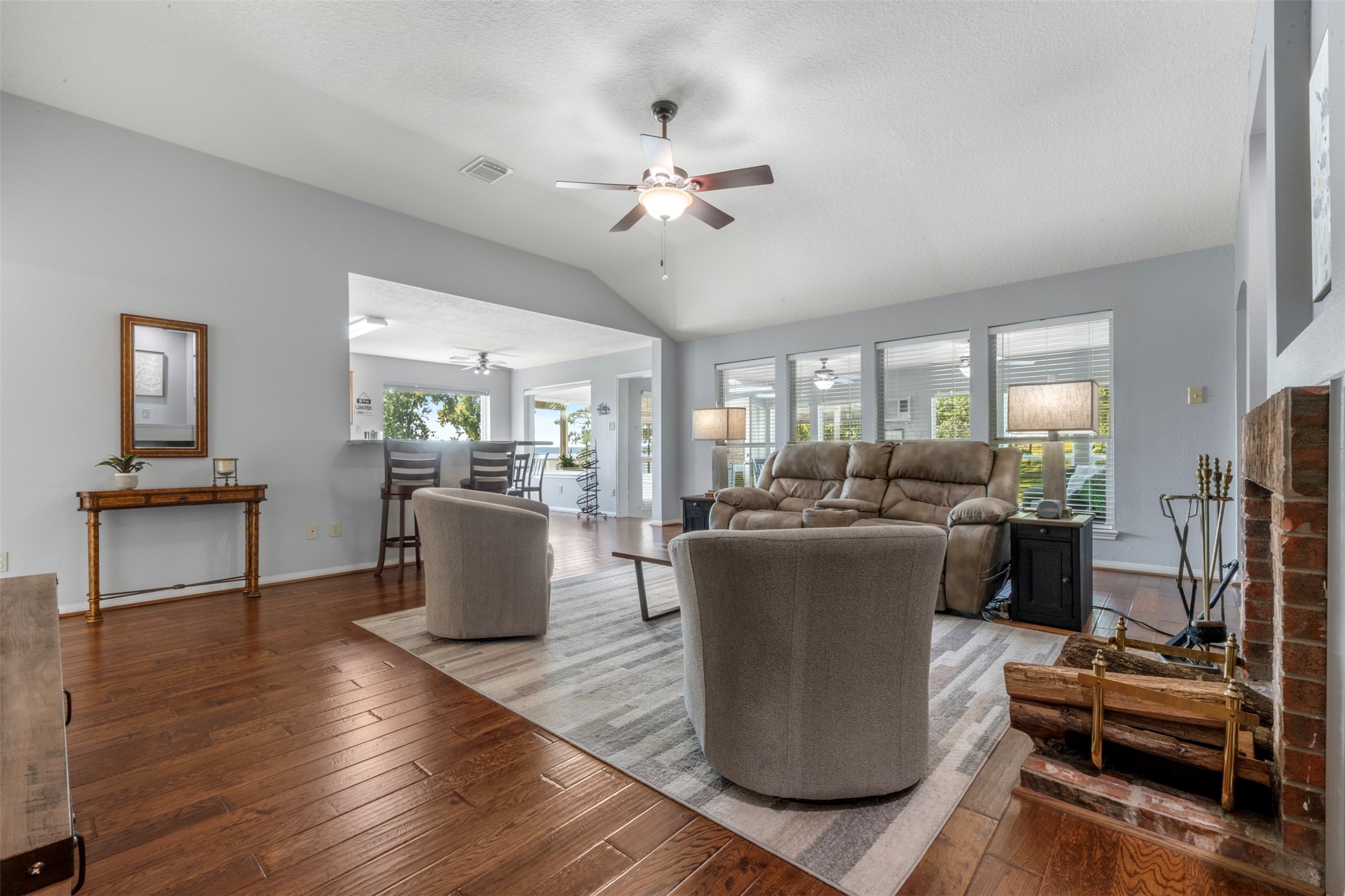 381 West Lake Drive Point Blank, TX 77364 - Photo 11 of 33 This angle highlights the home’s open concept, connecting the living room to the breakfast nook and kitchen. Wood floors and natural light enhance the welcoming atmosphere while maintaining an airy, connected feel.