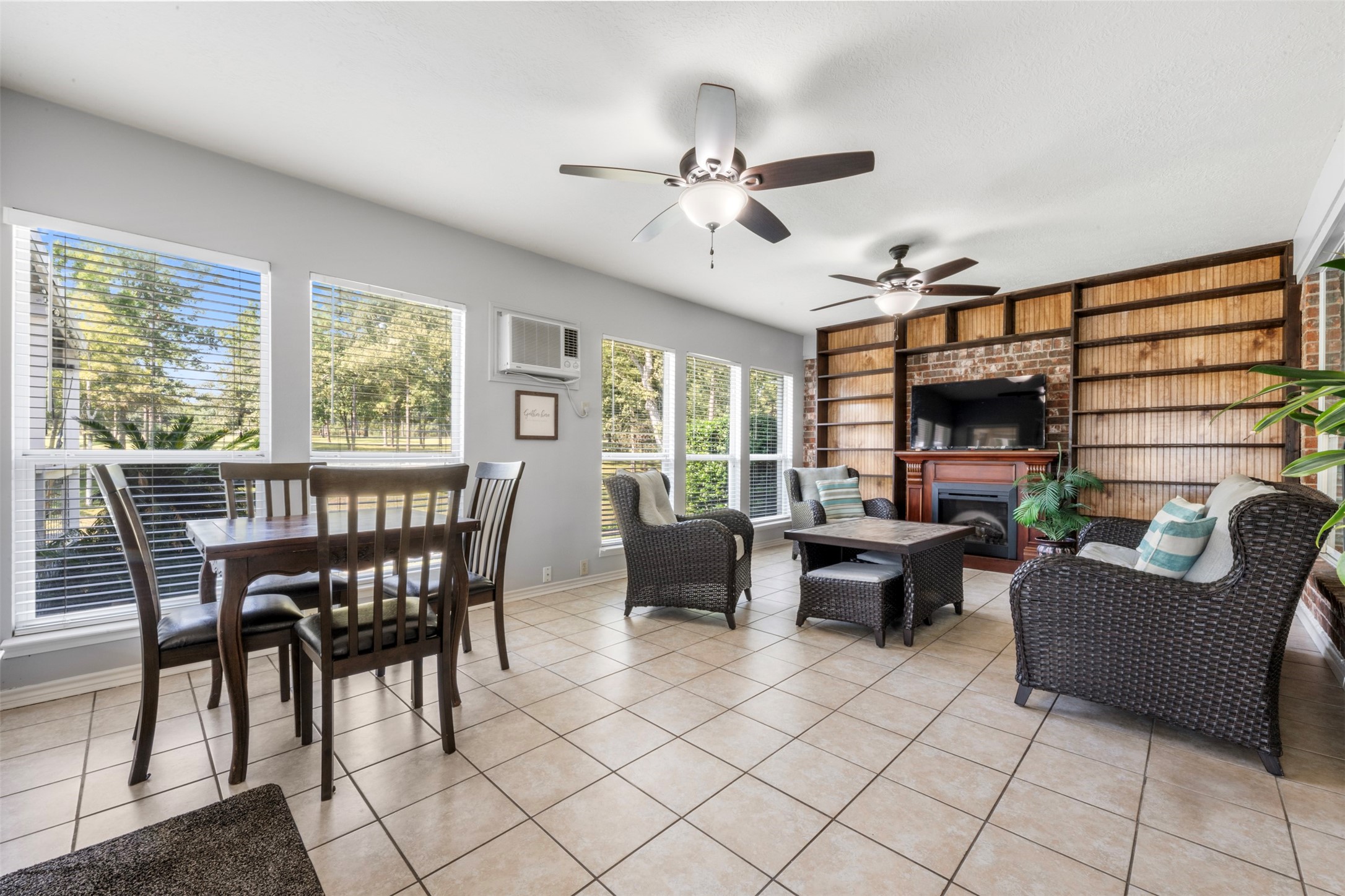 381 West Lake Drive Point Blank, TX 77364 - Photo 13 of 33 This bright sunroom is lined with windows, offering views of the backyard and beyond. With tile floors, ceiling fans, and built-in shelving, it’s a versatile space for relaxing, entertaining, or enjoying the natural light year-round.