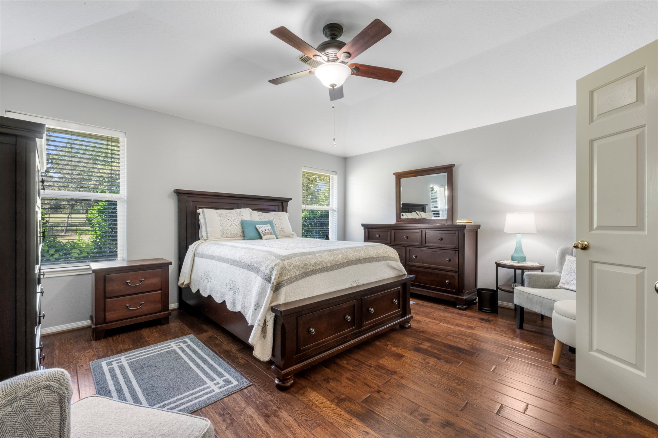381 West Lake Drive Point Blank, TX 77364 - Photo 15 of 33 The primary bedroom is a true retreat with wood flooring, soft neutral tones, and large windows that frame peaceful outdoor views. The layout easily accommodates larger furniture while maintaining a cozy feel.