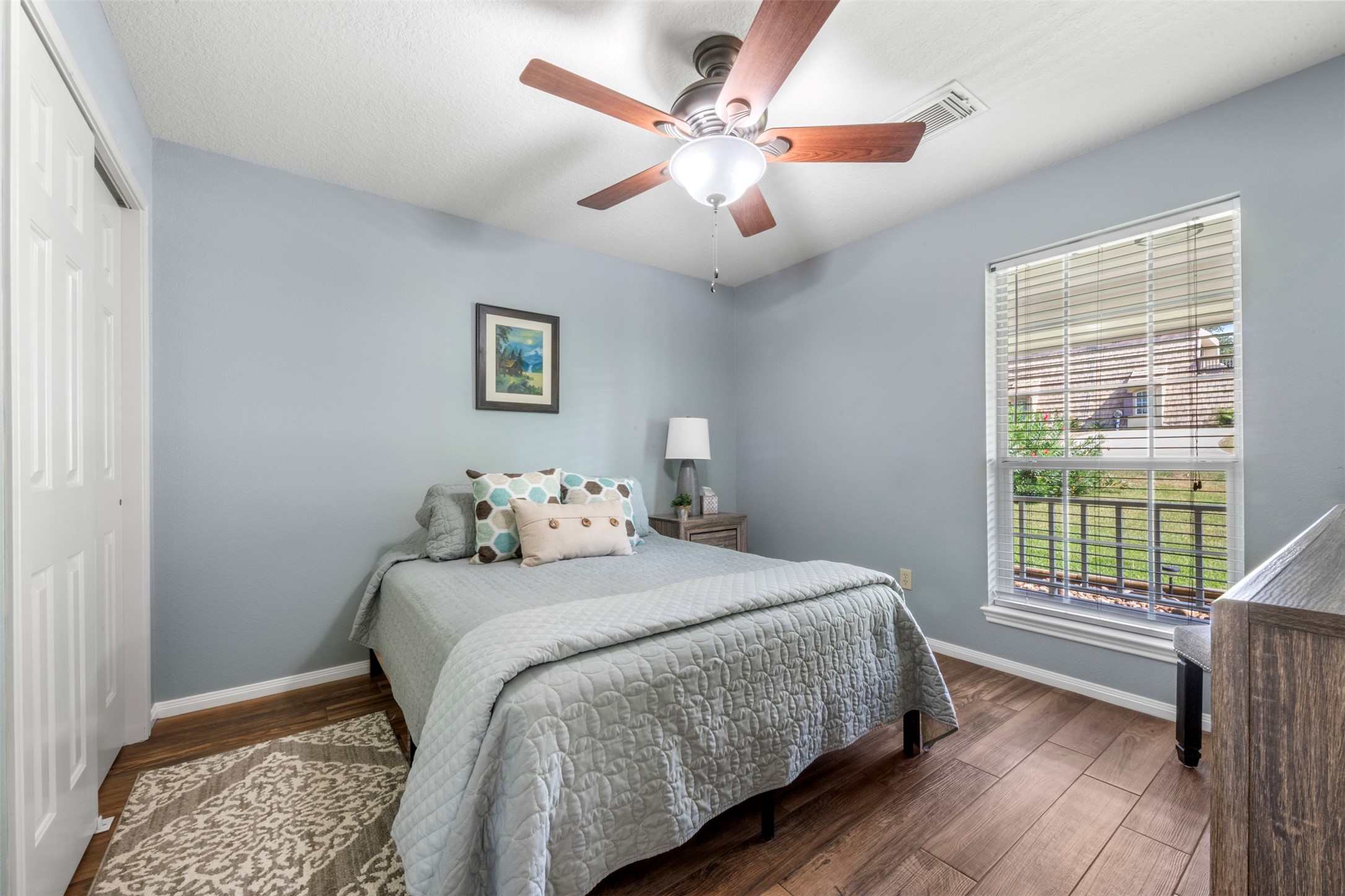 381 West Lake Drive Point Blank, TX 77364 - Photo 18 of 33 A comfortable guest bedroom with soft paint tones, ceiling fan, and a bright window view. Perfect for family & friends.