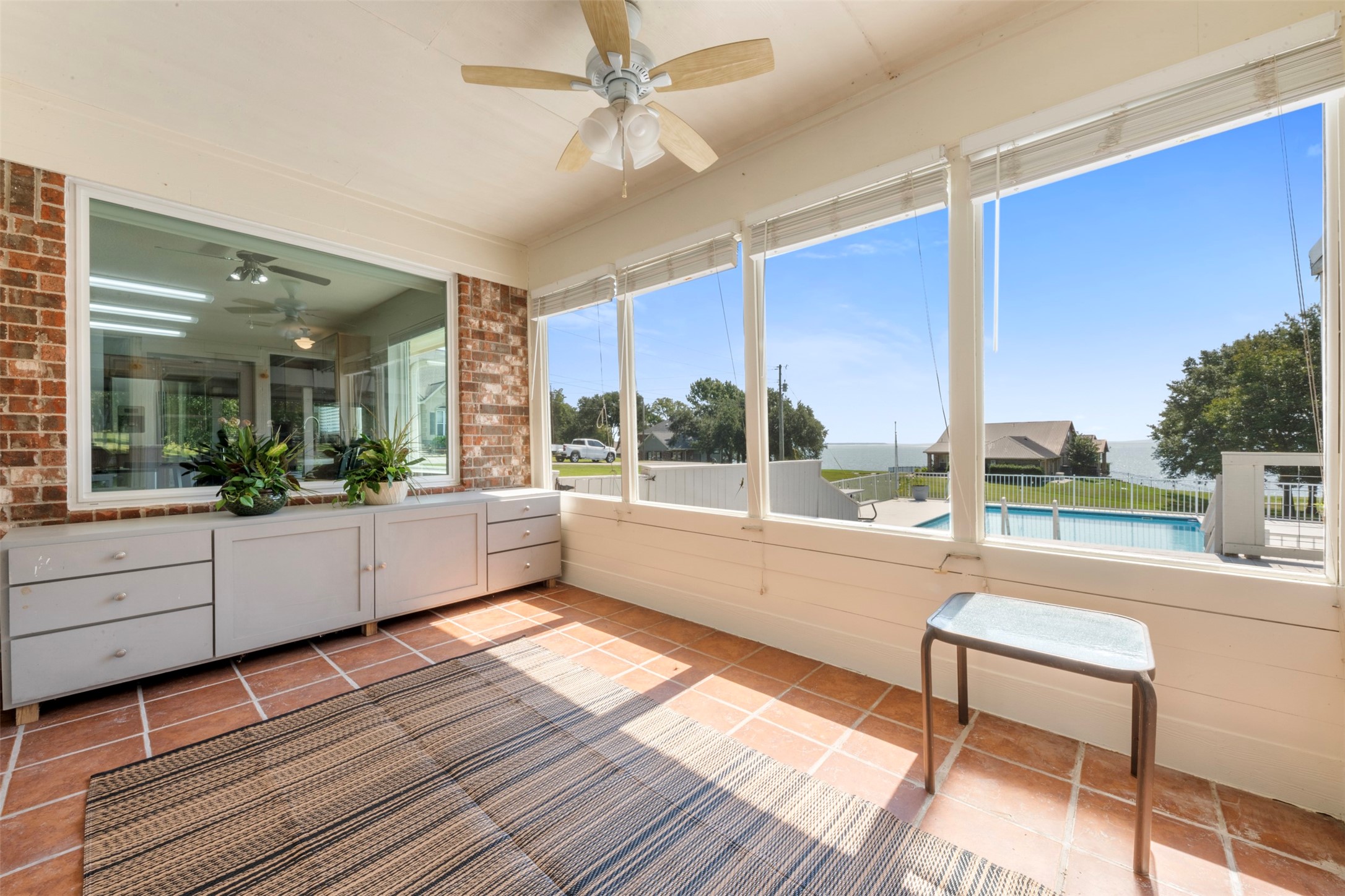 381 West Lake Drive Point Blank, TX 77364 - Photo 23 of 33 This second angle captures the tiled sunroom’s cozy design, built-in cabinetry, and sweeping pool and lake views. A versatile bonus space full of natural light.