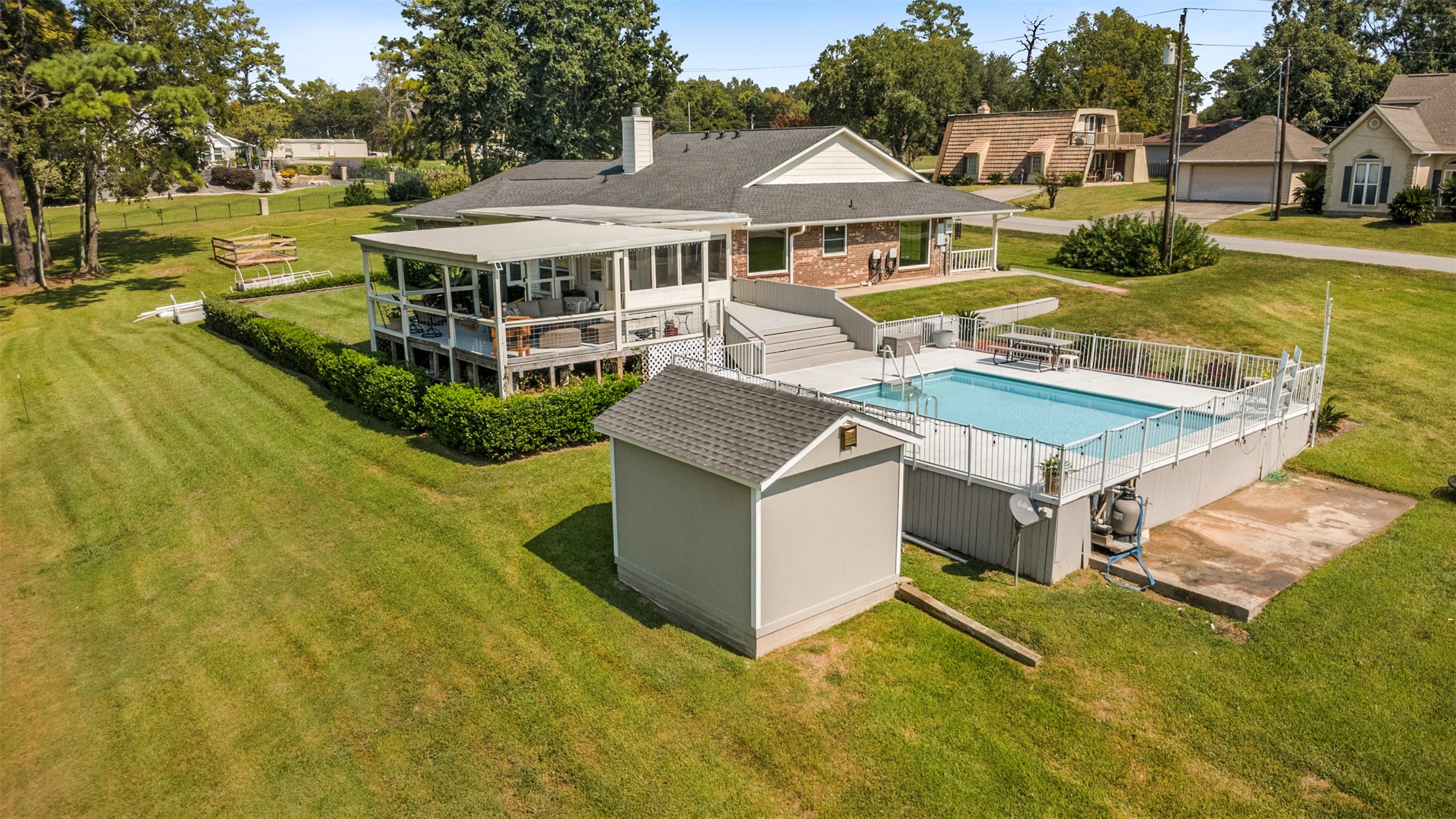 381 West Lake Drive Point Blank, TX 77364 - Photo 25 of 33 An overhead shot highlights the impressive outdoor layout, including the pool, covered deck, detached storage, and manicured lawn. A private setting with room to enjoy.