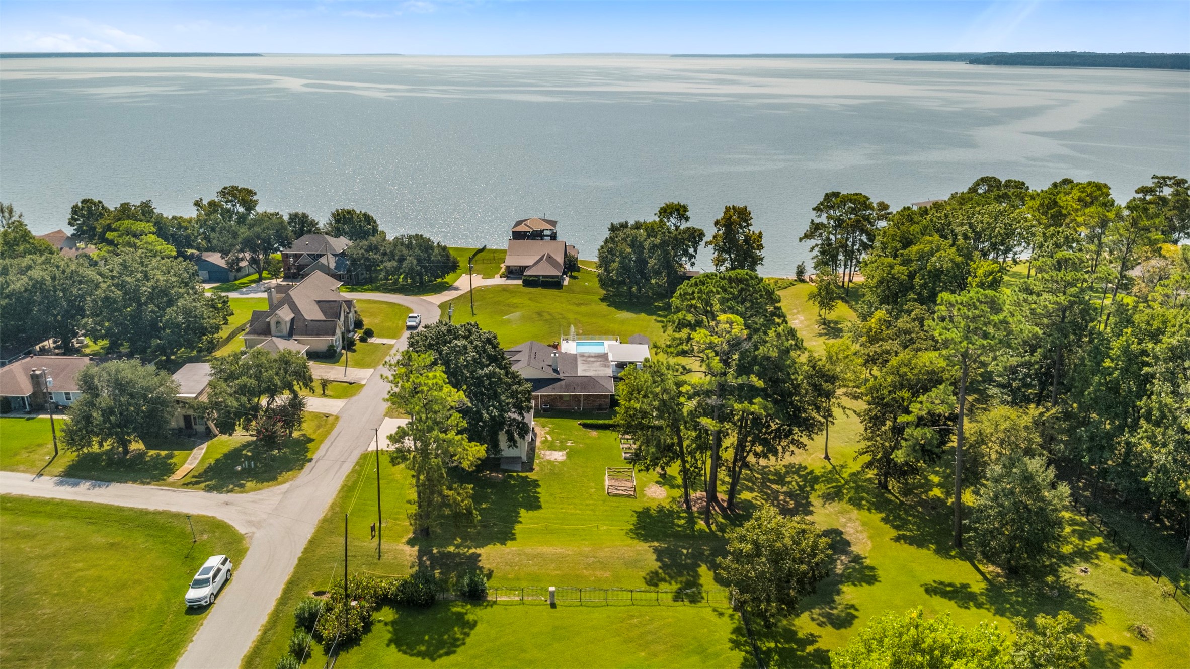 381 West Lake Drive Point Blank, TX 77364 - Photo 26 of 33 This breathtaking aerial shot highlights the home’s proximity to expansive Lake Livingston. Nestled in a peaceful lakeside community, the property offers serene water views, mature trees, and open green space — all just steps from the shoreline.