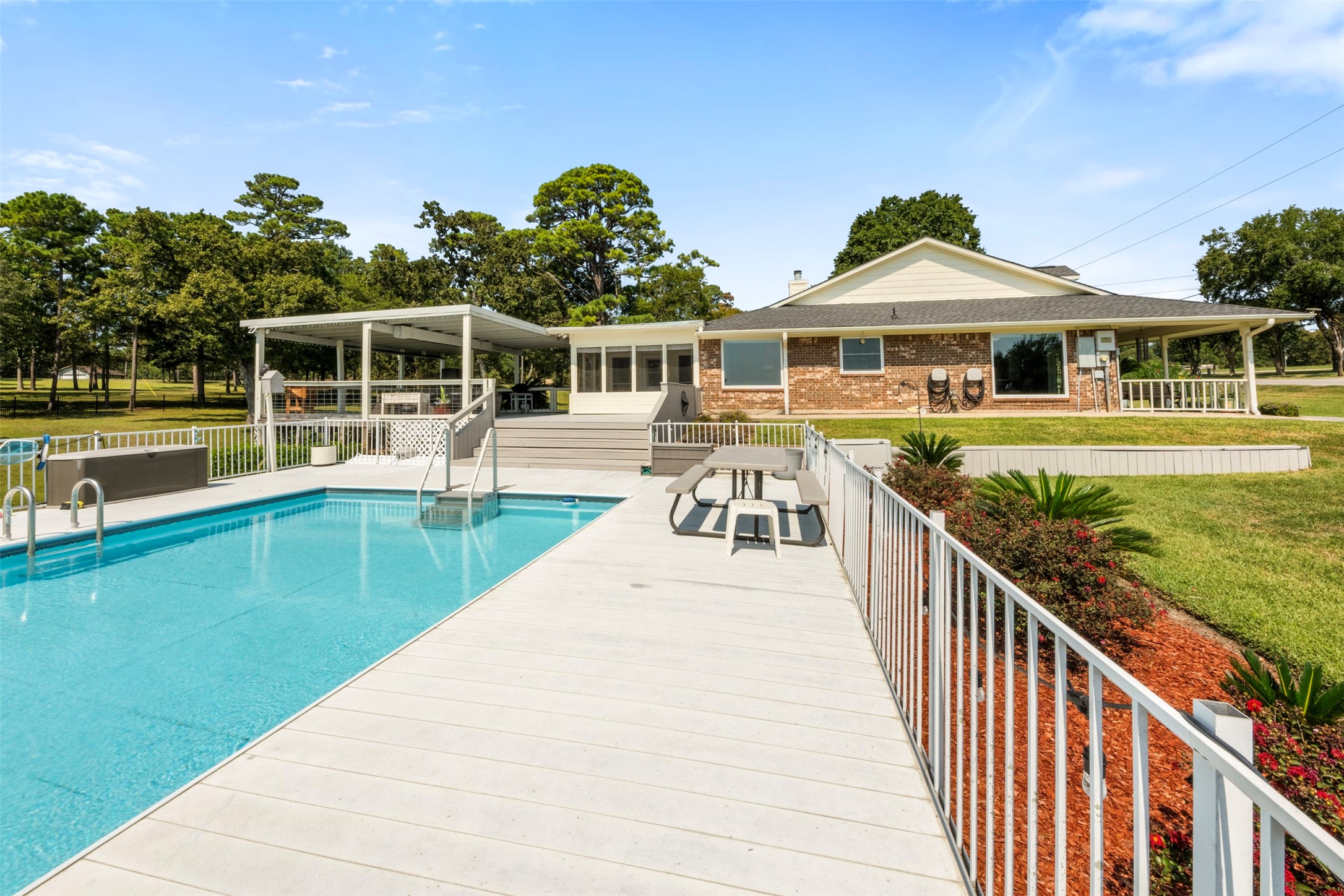 381 West Lake Drive Point Blank, TX 77364 - Photo 29 of 33 A refreshing pool with extended decking and seating areas — the ultimate space for summer fun. Surrounded by landscaping and open skies, it’s an inviting backyard centerpiece.