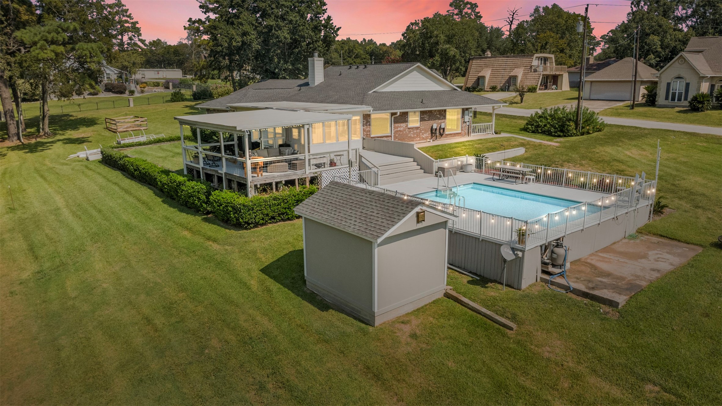 381 West Lake Drive Point Blank, TX 77364 - Photo 32 of 33 As evening falls, the pool and deck come alive with soft lighting, creating a magical space for evening swims, gatherings, and enjoying the sunset.