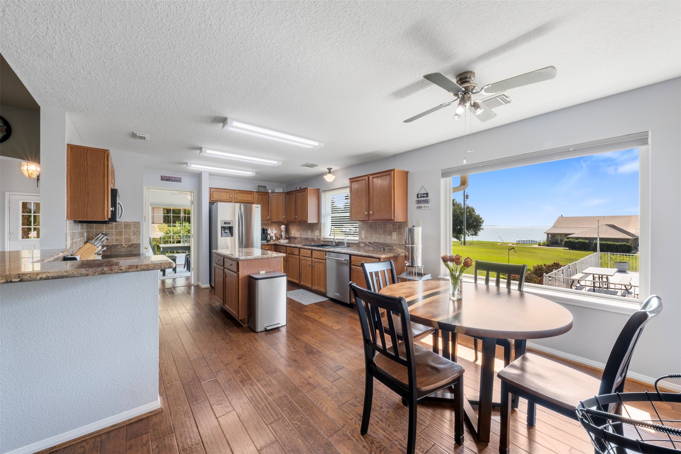 381 West Lake Drive Point Blank, TX 77364 - Photo 8 of 33 Enjoy your morning coffee with a view! The breakfast nook and open kitchen flow seamlessly, offering expansive windows overlooking the lake. A perfect scenery for everyday living.