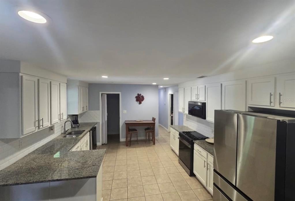 9989 Leahy Road Jacksonville, FL 32246 - Photo 2 of 21 a kitchen with stainless steel appliances granite countertop a refrigerator stove microwave and sink