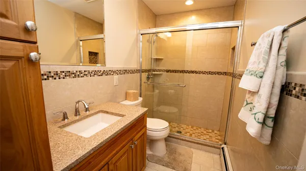 a bathroom with a granite countertop sink toilet and shower
