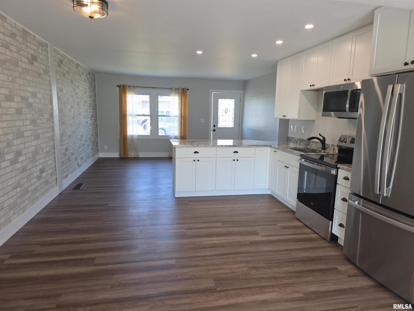 1031 Galbraith Drive Clinton, IA 52732 - Photo 13 of 35 a large kitchen with stainless steel appliances a large counter top a stove and a refrigerator