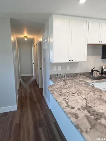 a view of a hallway with wooden floor and a chandelier