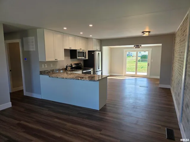 a kitchen with granite countertop a stove and a refrigerator