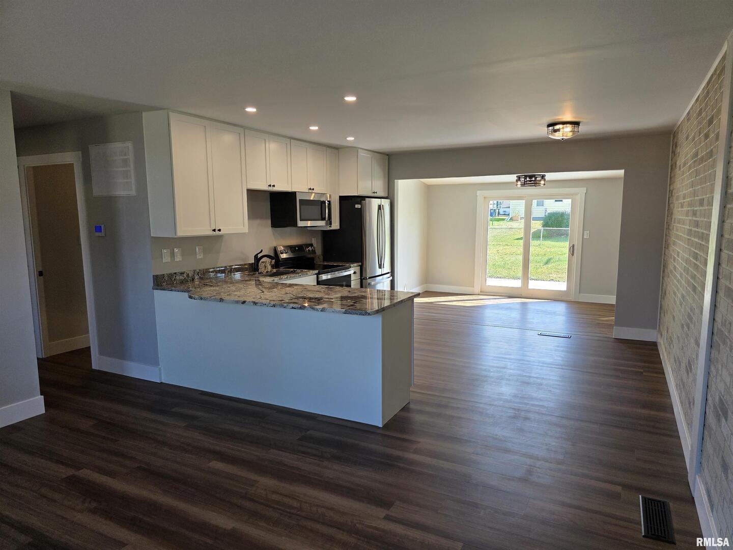 1031 Galbraith Drive Clinton, IA 52732 - Photo 7 of 35 a kitchen with granite countertop a stove and a refrigerator