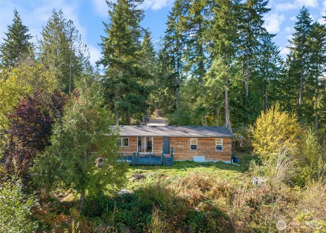a view of a house with a backyard and trees