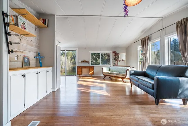 a living room with furniture wooden floor and a large window