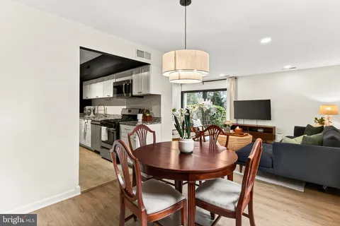 a dining room with furniture a chandelier and wooden floor