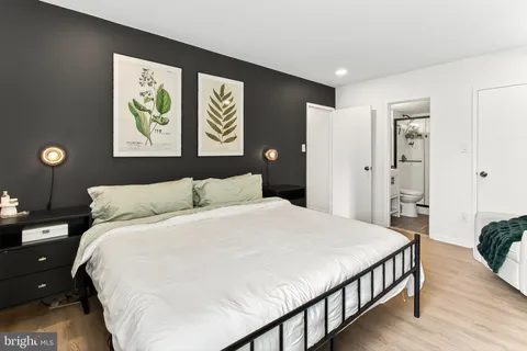 a bedroom with a bed and painting on the wall